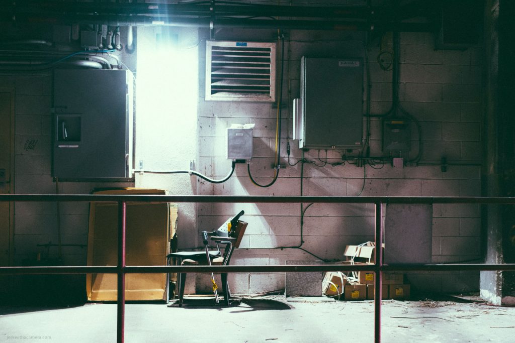 Industrial workspace with exposed wiring, a chair, and cardboard boxes