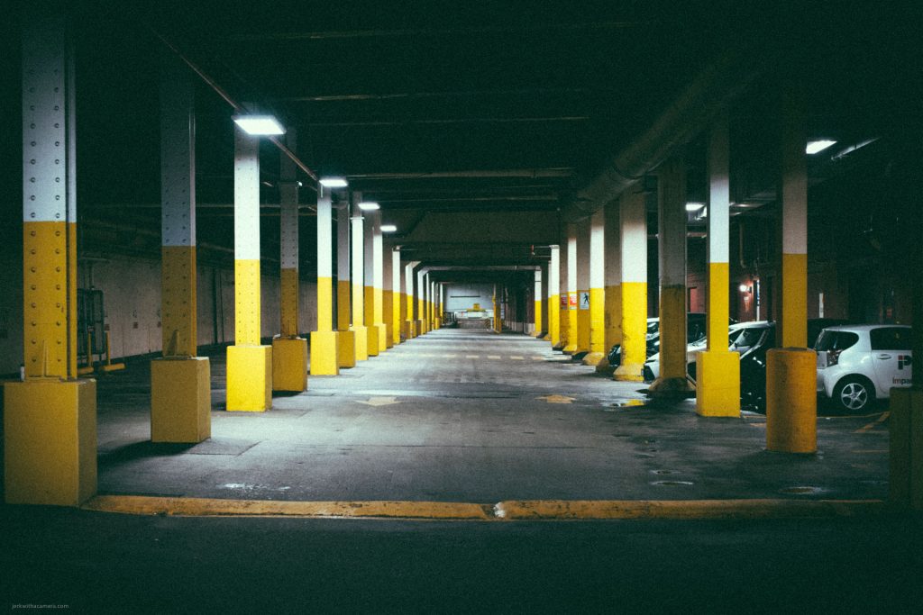 Underground parking garage with yellow pillars and dim lighting