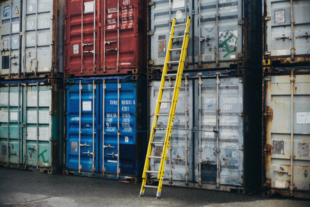 A bright yellow ladder propped against a colorful mosaic of shipping containers at Emily Carr University in Vancouver, captured with a Leica M-D (Typ 262) rangefinder and Canon 50mm f/1.4 LTM lens.