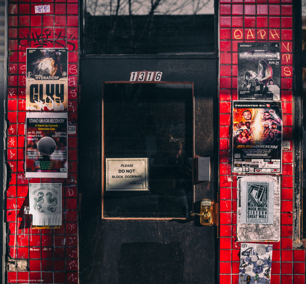 Red-tiled storefront entrance decorated with event posters.