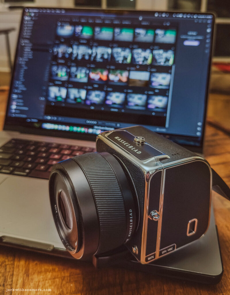 Hasselblad 907X camera with a CFV 100C Digital Back placed in front of a laptop displaying photo editing software