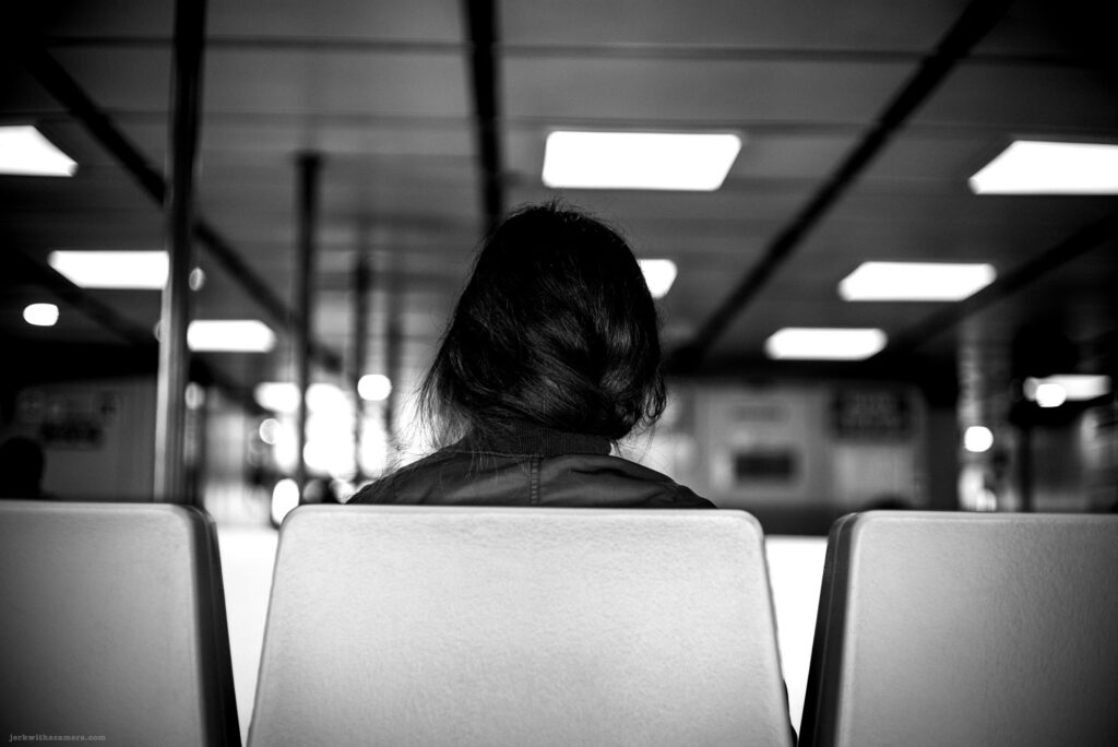 Back of a woman sitting on a SeaBus seat